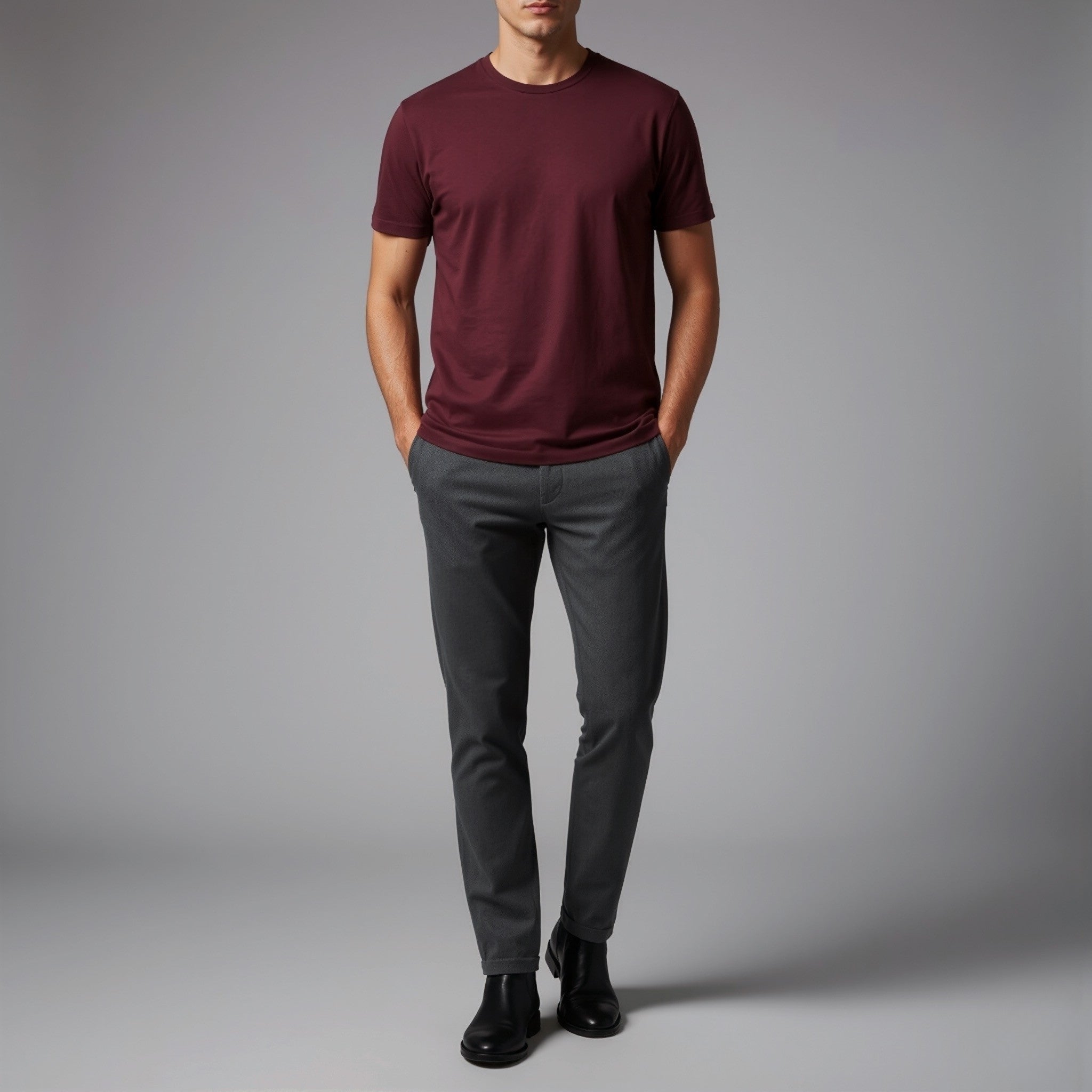 Person wearing a moleculuxe bordeaux maroon t-shirt and gray pants on a gray background