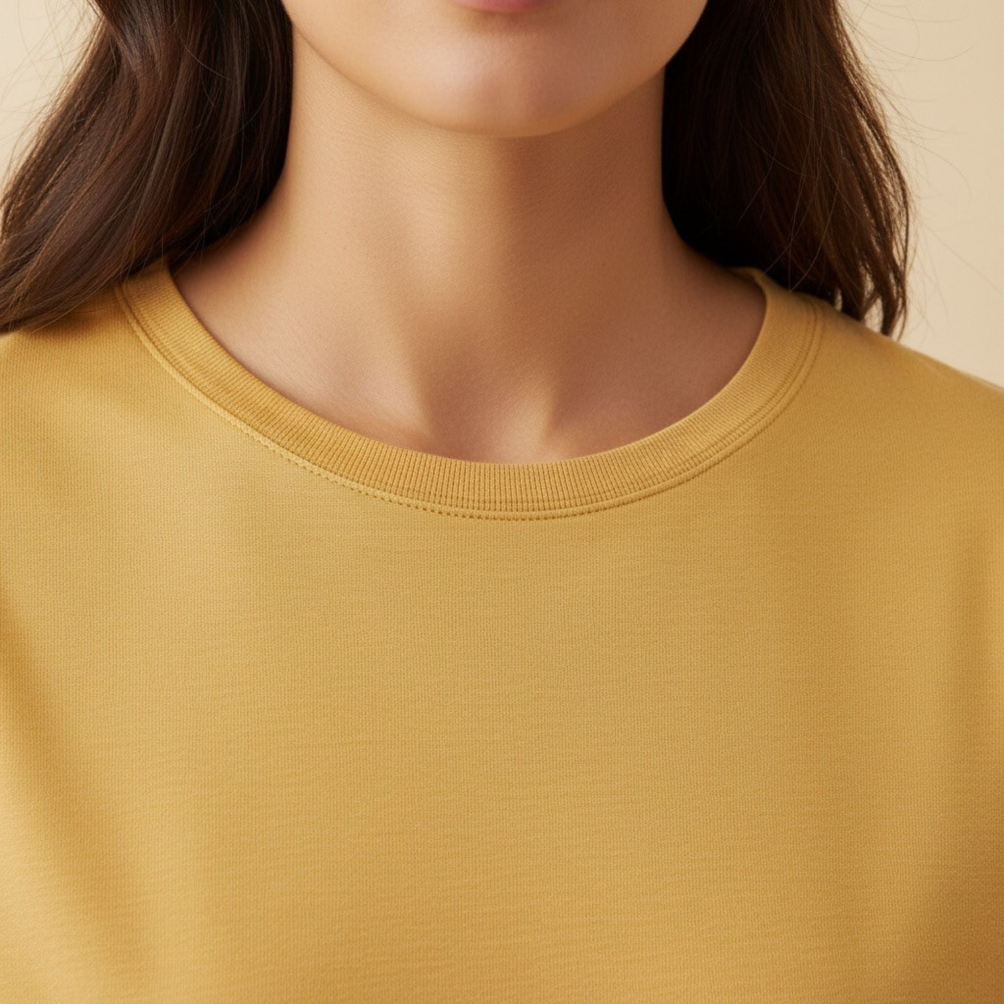 Close-up of a moleculuxe Champagne Sand yellow sweater worn by a person