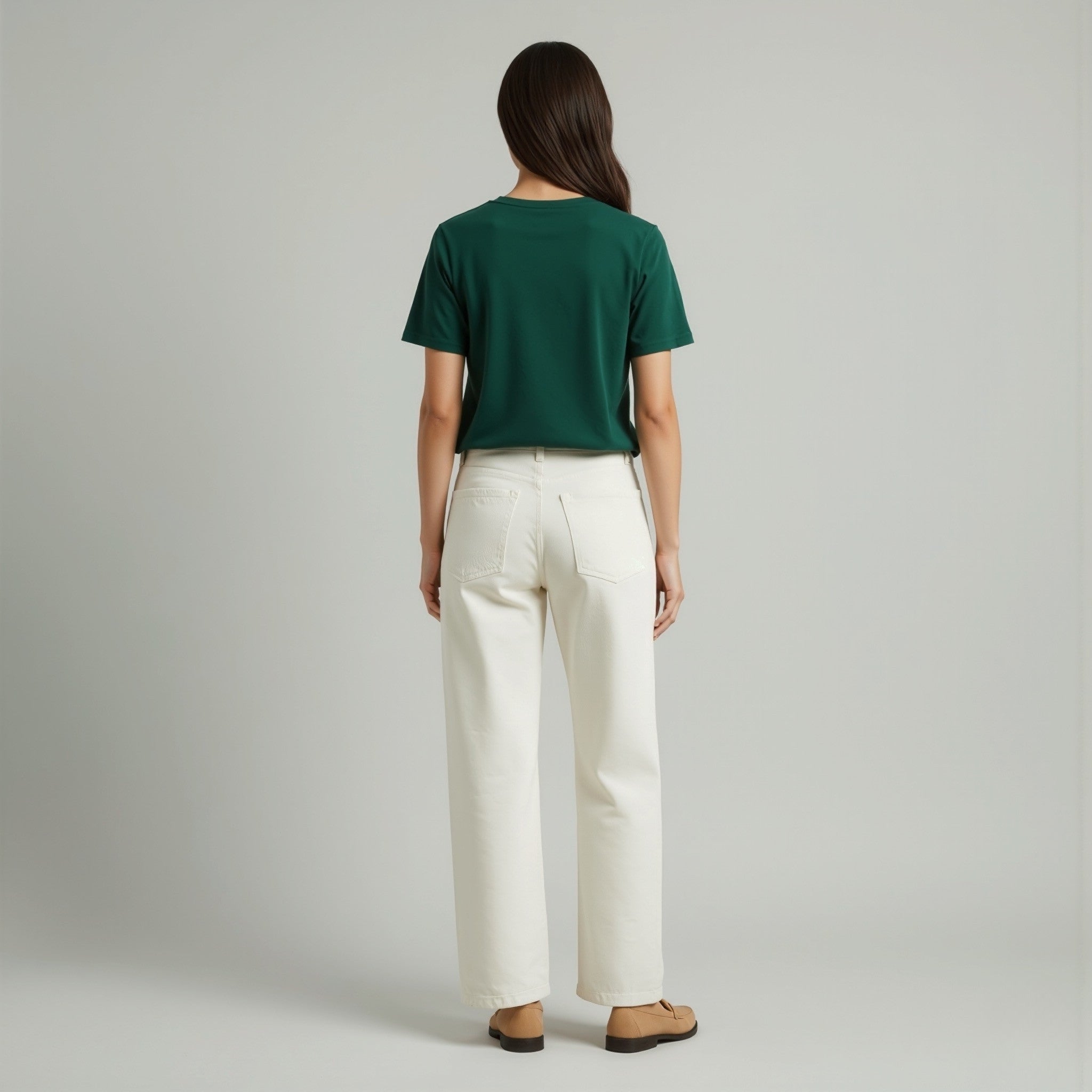 Person wearing a moleculuxe emerald forest green shirt and white pants on a gray background