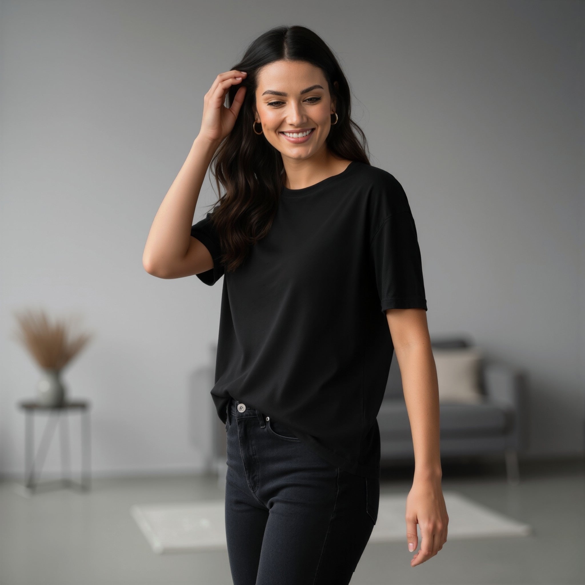 Woman wearing a moleculuxe midnight noir black t-shirt and dark jeans in a minimalistic room.