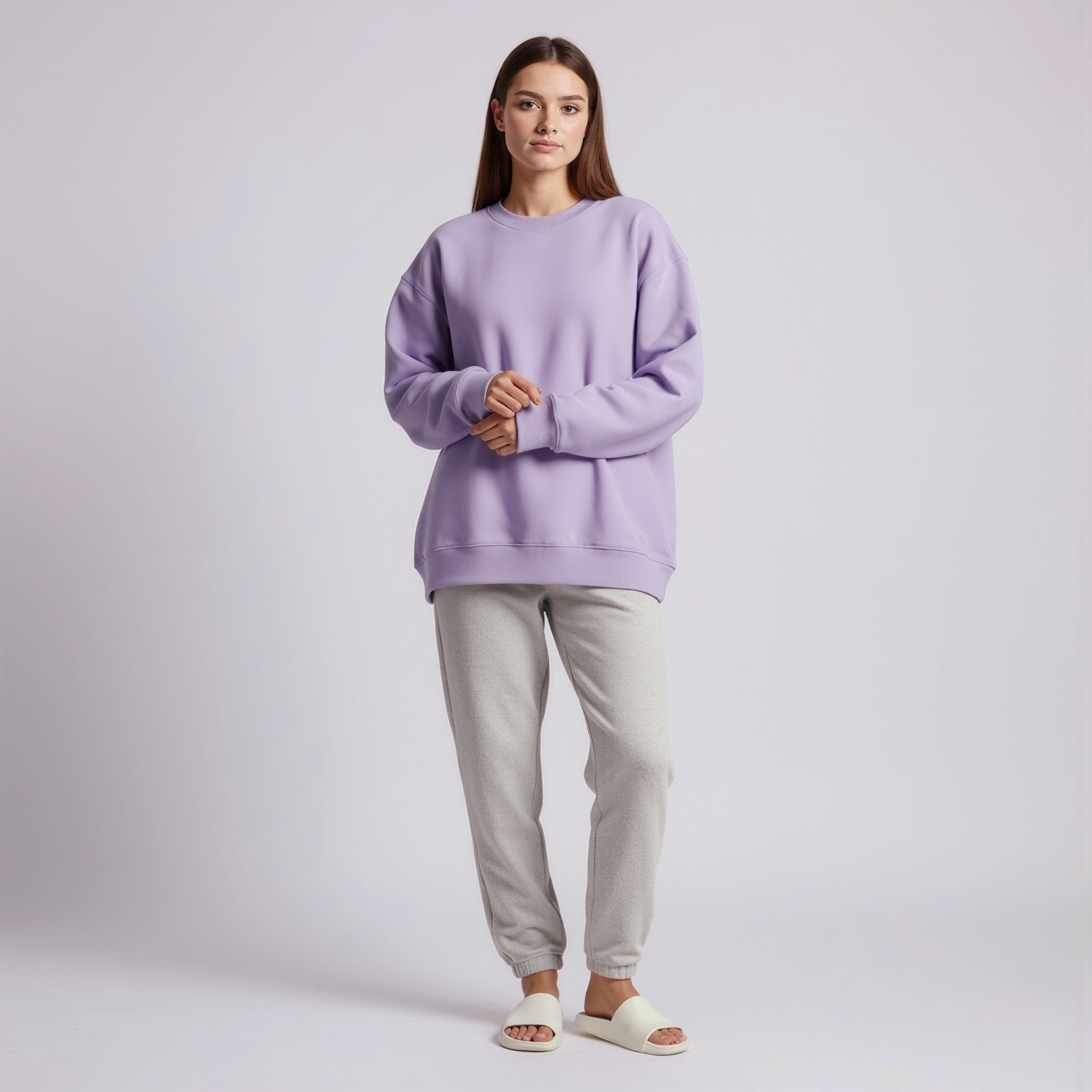Person wearing a moleculuxe Amethyst Haze purple sweatshirt and gray pants on a light gray background