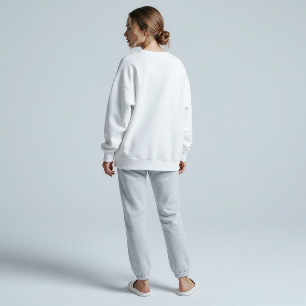 Person wearing a moleculuxe pristine white sweatshirt and gray pants on a light gray background