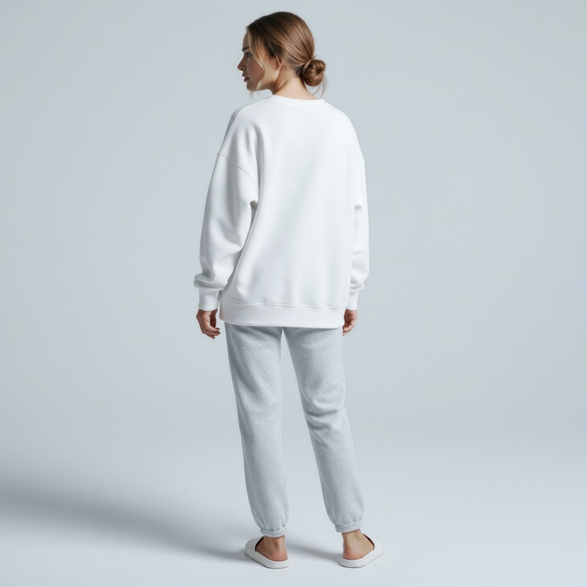 Person wearing a moleculuxe pristine white sweatshirt and gray pants on a light gray background