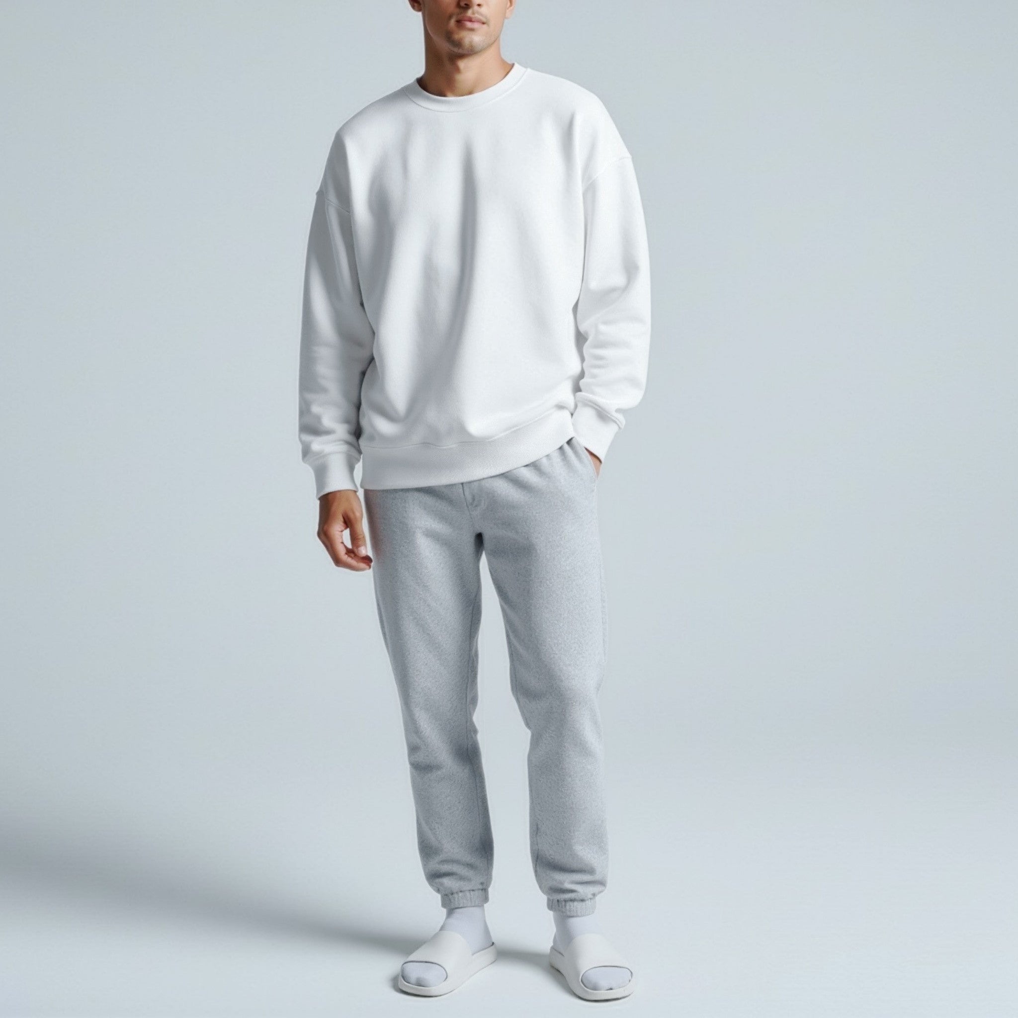 Person wearing a moleculuxe pristine white sweatshirt and gray pants on a light gray background