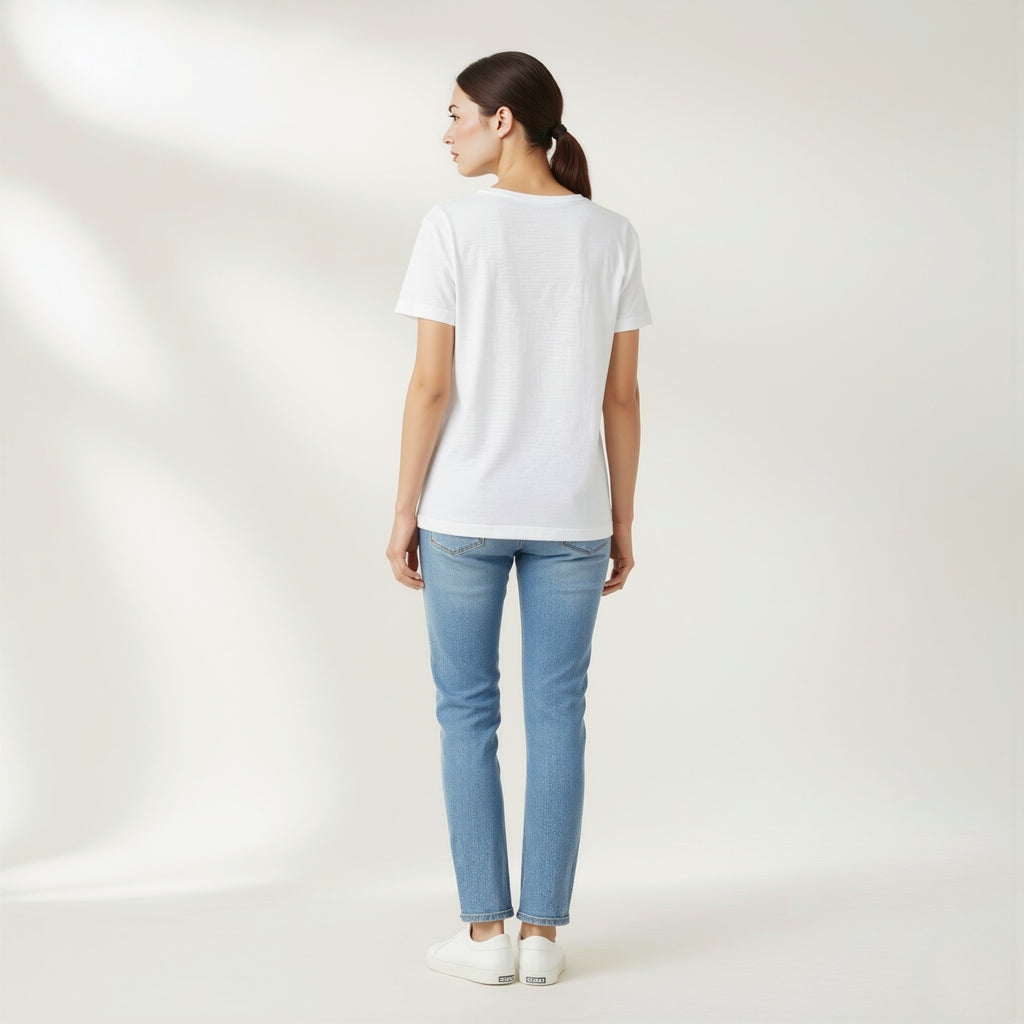 Woman wearing a moleculuxe pristine white t-shirt and light blue jeans on a plain background