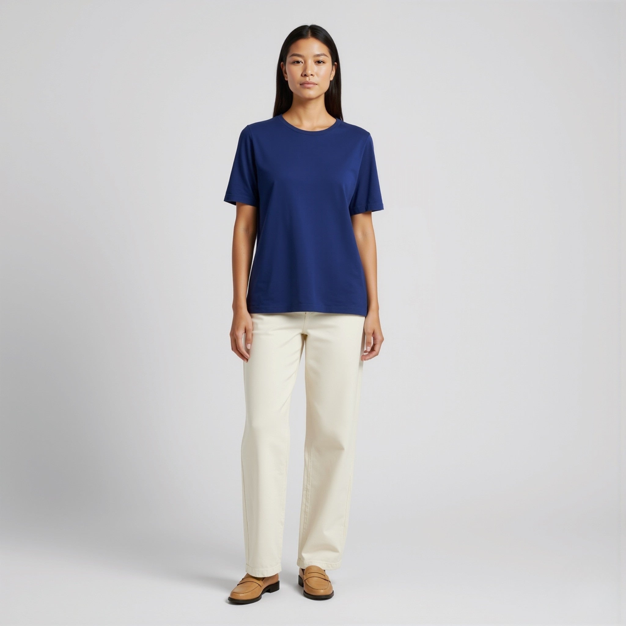 Person wearing a moleculuxe Sapphire Majesty blue shirt and white pants on a plain background
