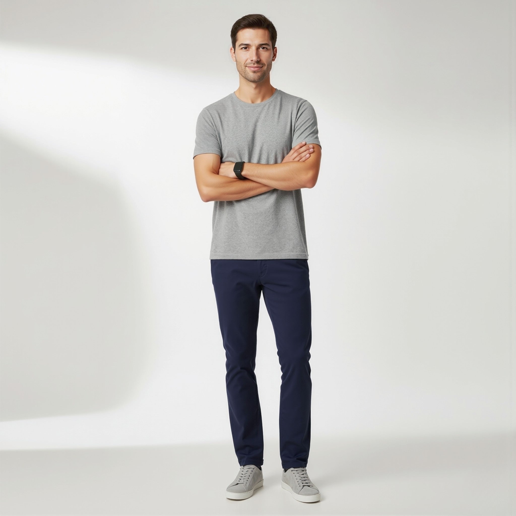 Man wearing a moleculuxe silver mist gray t-shirt and navy pants standing against a white background