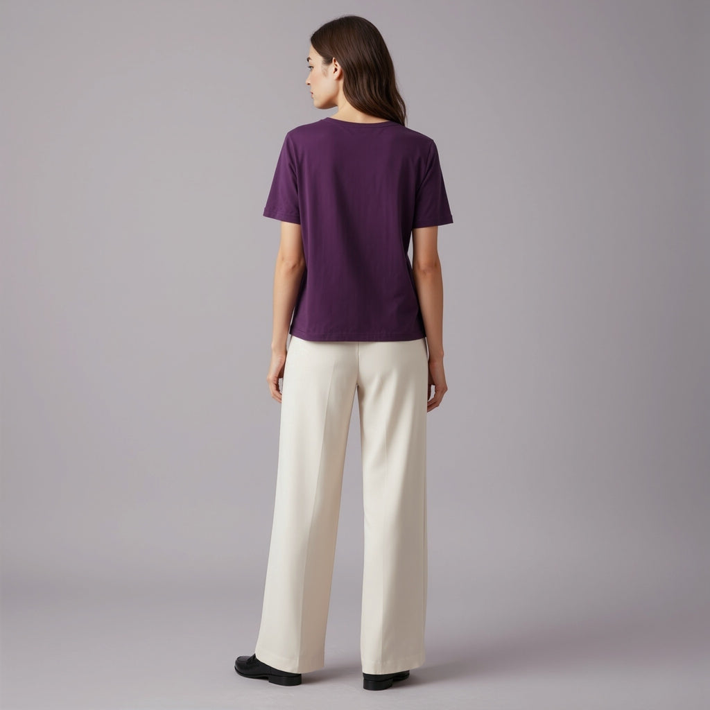 Person wearing a moleculuxe imperial violet purple shirt and white pants on a gray background