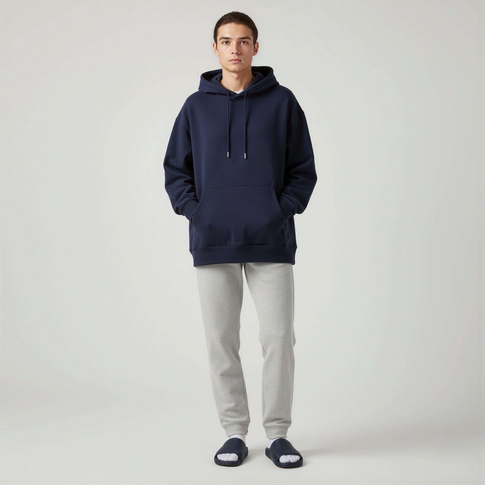Person wearing a moleculuxe midnight ocean navy hoodie and light gray pants on a white background