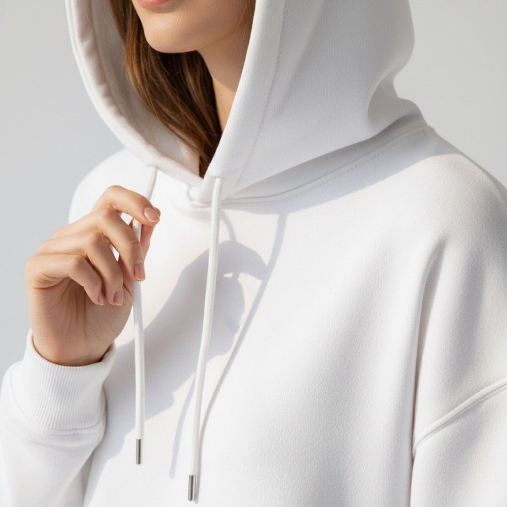 Close-up of a person wearing a moleculuxe pristine white hoodie with a neutral background